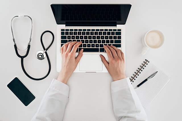 partial-view-of-doctor-at-workplace-with-laptop-s-2024-11-19-07-23-37-utc (1)