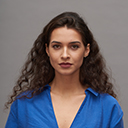 Young beautiful female fashion model with dark long wavy hair looking at camera
